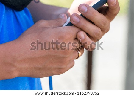 Closeup of male hand holding and using modern smart phone.