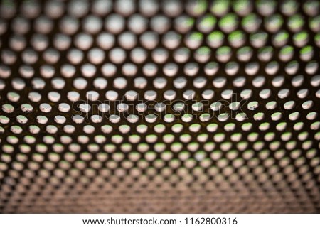 A sheet of metal with round holes, standing vertically. Background, texture