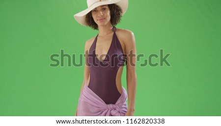 African American woman in sarong and bathing suit and sun hat on green screen