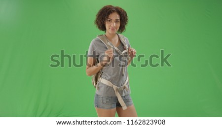 African American millennial woman posing with backpack ready on green screen