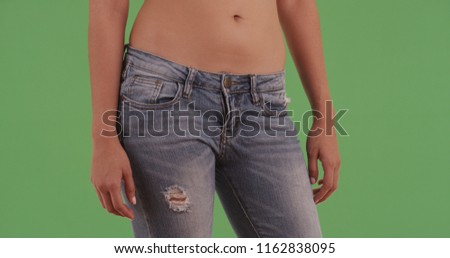 Hips of millennial latina with ripped jeans on green screen