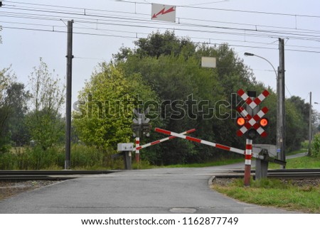 Train crossing with red signal and closing barriers