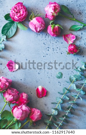 Pink roses on a grey background. Flat lay flowers composition, top view.