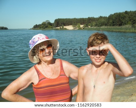 Grandmother and grandson on the beach close-up/a beautuful blonde woman in a hat and boy on the sea/Summer landscape/Happy family photography