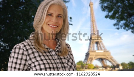 Woman smiles at camera with the Eiffel Tower in the background