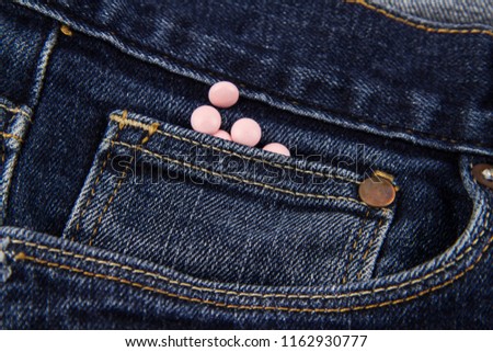 Tablets in a blue jeans pocket
