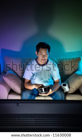 Man watching television alone at night