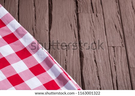 Rustic wooden background with red checkered napkins