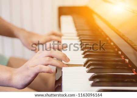 Select focus and soft focus.Close-up of a wooden piano set near a window to receive warmth from the sunshine in the morning of winter in Thailand. The most melodious musical instrument in a beautiful