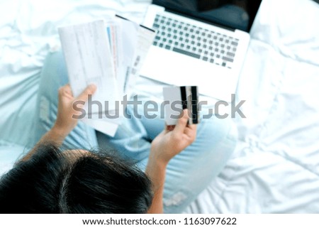Women modern lifestyle she sat in the living room, she is spending The bill is in her hands and using his tablet pc and holding credit card her online To buy product and Pay debts in the internet