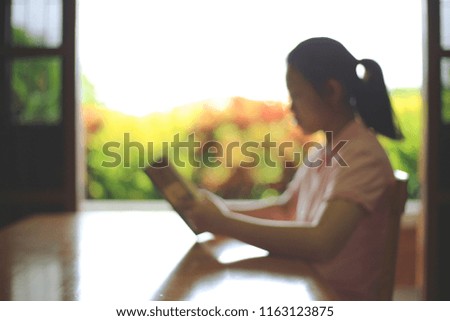 Blurry picture of a girl reading a book in the living room