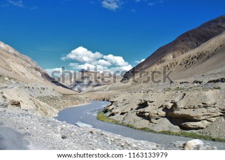 "S Curve" made by flowing River from one of the Himalayan mountains. Picture have great foreground and background with Bright blue sky and white clouds.
