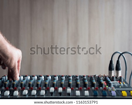 Adjusting buttons on audio mixer in music studio