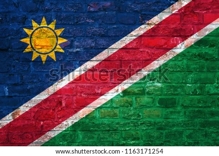 Flag of Namibia over an old brick wall background, surface