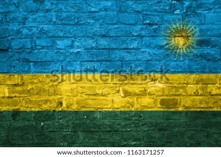 Flag of Rwanda over an old brick wall background, surface