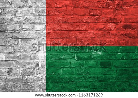 Flag of Madagascar over an old brick wall background, surface