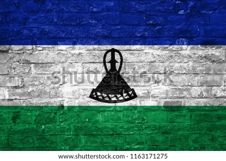 Flag of Lesotho over an old brick wall background, surface