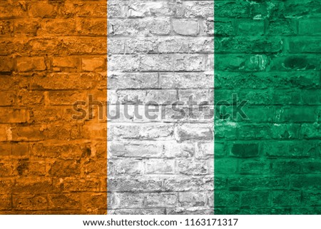 Flag of Cote d'Ivoire over an old brick wall background, surface