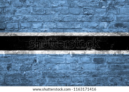 Flag of Botswana over an old brick wall background, surface