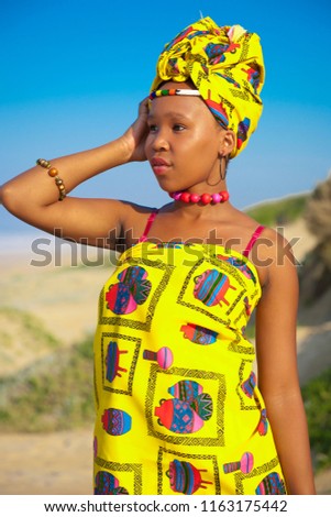 Colorful portrait of young attractive African woman on a sandy beach 