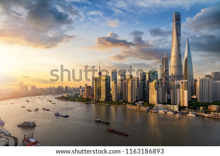 View over the Huangpu river to the modern skyline of Shanghai, China, during sunset time
