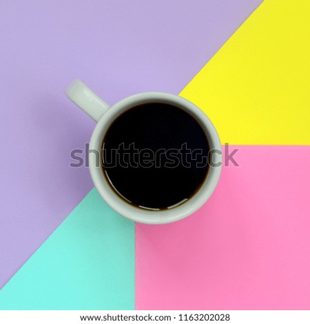 Small white coffee cup on texture background of fashion pastel blue, yellow, violet and pink colors paper in minimal concept.