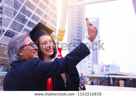 She is  Graduate and wearing  graduate's dress. They  are use smartphone. They are happy in good time. Photo concept  Education and success.