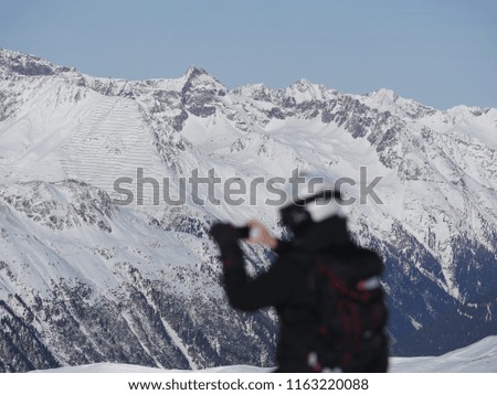 woman taking picture with camera in ski resort