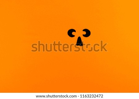 The face of a pumpkin monster made of paper on an orange background. Copy spase. Party holiday Halloween.