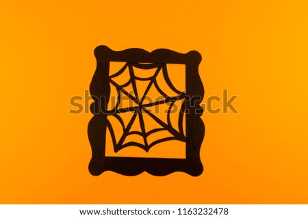 A black web of paper on an orange background. Copy the spase. Festive Halloween.