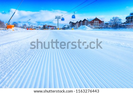 Close-up groomed snow at Bansko resort, Bulgaria panorama with ski slope and cable car lift Royalty-Free Stock Photo #1163276443