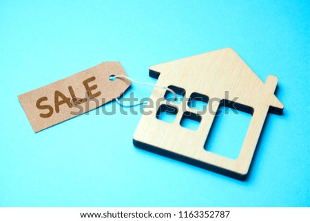 Sale of house. Wooden house model with a label SALE