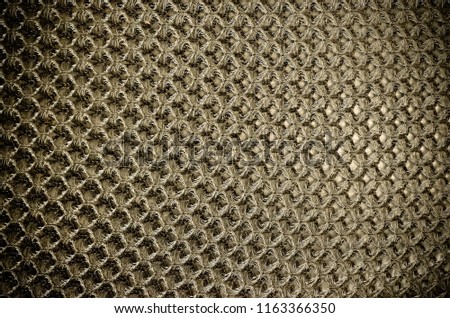 Gold fabric mesh chair cushion, close up.
plaiting isolated on the black background