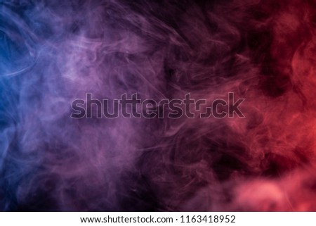 Thick red,blue and white smoke on a black isolated background. Background from the smoke of vape
