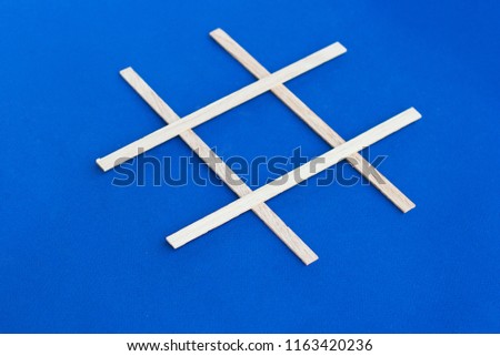 Wooden hashtag icon on blue paper. Unusual icon of tag from wood.