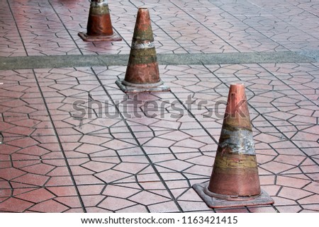 Old traffic cones placed on the sidewalk.