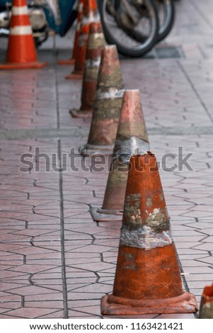 Old traffic cones placed on the sidewalk.