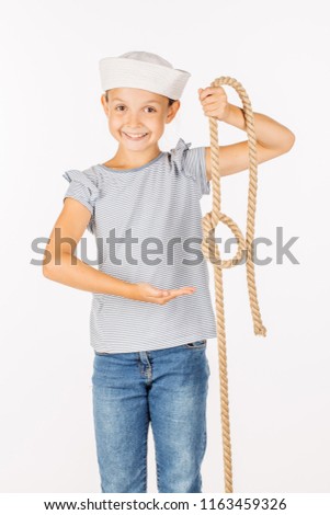 Cute little girl wearing a sailor costume and looking at the camera on white background.