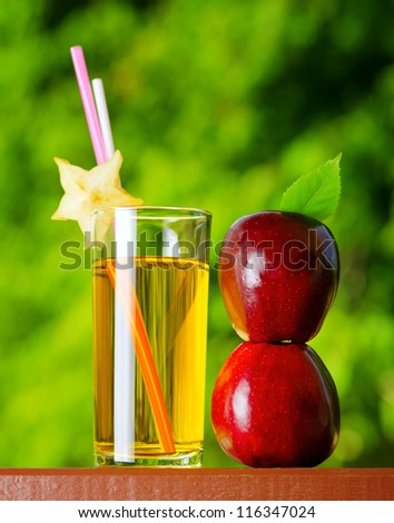 Glass of apple juice in a garden.