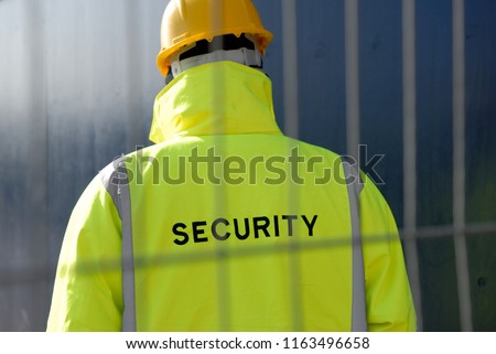 Security guard and protective fence. Royalty-Free Stock Photo #1163496658