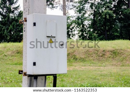 Box with electricity on a concrete column with the sign danger 