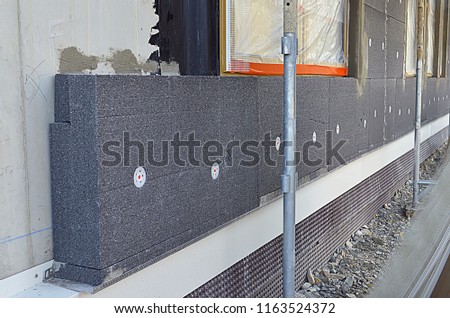External thermal insulation of a building on a construction site with styrofoam sheets. Royalty-Free Stock Photo #1163524372