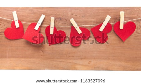  Tiny red hearts on wooden background.