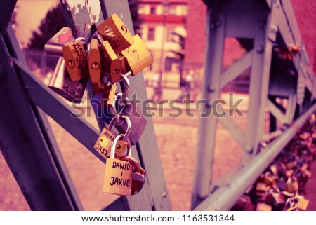 Padlocks on a bridge. Male names on a lock, can be a concept about homosexual relationships. Lock as symbol of true and endless love. Toned picture in pink color.