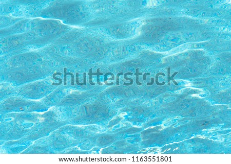 Blue and bright ripple water and surface in swimming pool. Abstract background motion gentle wave in pool