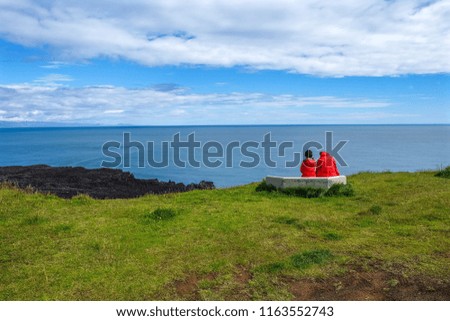Couple relationship friendship sitting together looking at the ocean slow life.