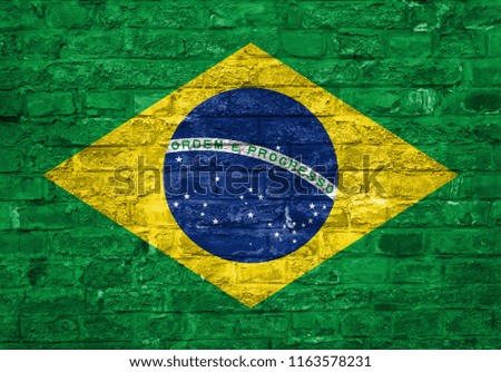 Flag of Brazil over an old brick wall background, surface.