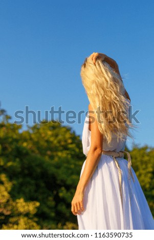 woman in white dress with beautiful hair looking into the distance