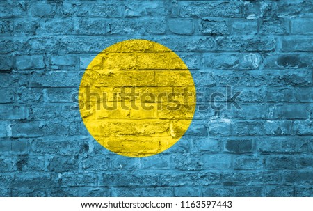 Flag of Palau over an old brick wall background, surface.