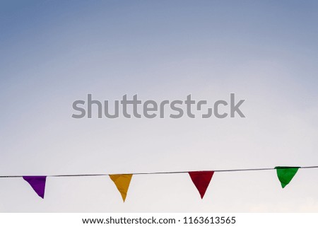 colorful garlands waving in the wind against a blue sky ideal for decorating a birthday.